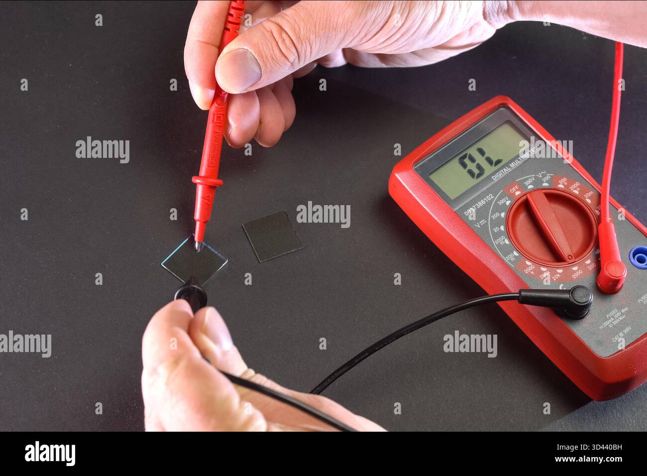 Measurement of product electrical parameters using a multimeter. Stock Photo
