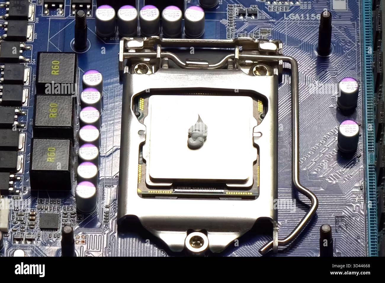 Drawing thermal paste on the computer processor. Installing a cooling system on a CPU processor Stock Photo