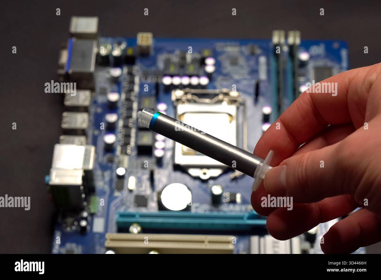 Drawing thermal paste on the computer processor. Installing a cooling system on a CPU processor Stock Photo