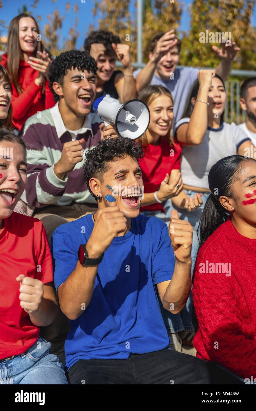 Young diverse fans intensely watching a sports game, cheering and ...