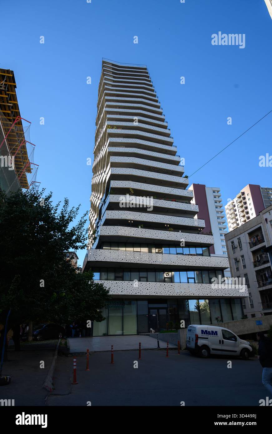 Long Rectangular Pyramid Building Modern pyramid-shaped residential building with white balconies and ...
