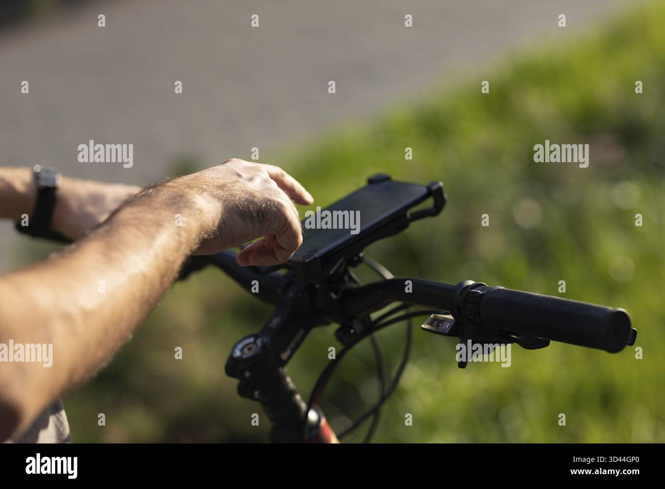Man planning route using GPS navigation application in mobile phone on his bicycle bike Stock Photo