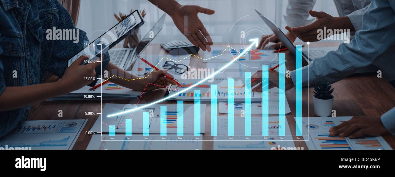 Diverse team working together in a professional setting, analyzing charts and graphs for growth strategy while using digital devices on the table Stock Photo