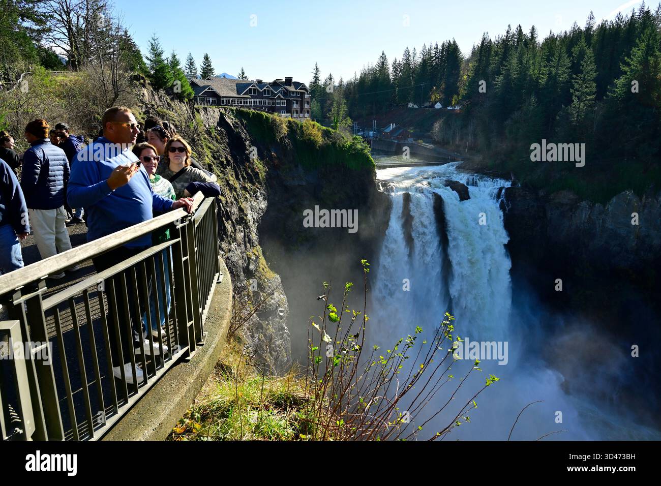 People gather at the viewing platform overlooking Snoqualmie Falls, taking in the mist and beauty of this iconic Pacific Northwest landmark. Stock Photo
