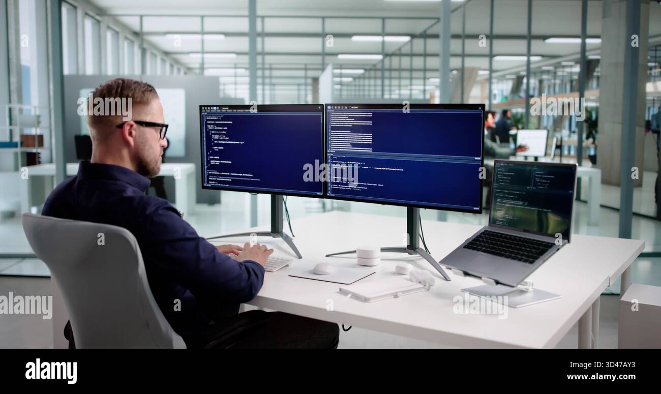 Young Programmer Man Coding Software On Desktop Computer At Office. Stock Photo