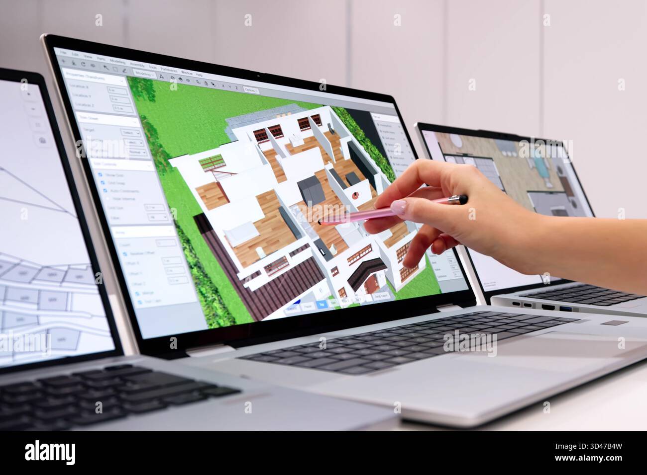 Young Male Engineer Using 3D CAD Software For House Design Stock Photo