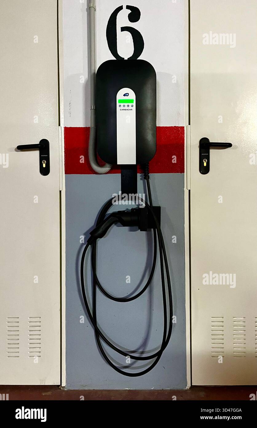 Wall mounted Cargacar box and cable hybrid electric car charging point in a private underground parking space Santander Cantabria Spain Europe - Smartphone Captured Stock Image
