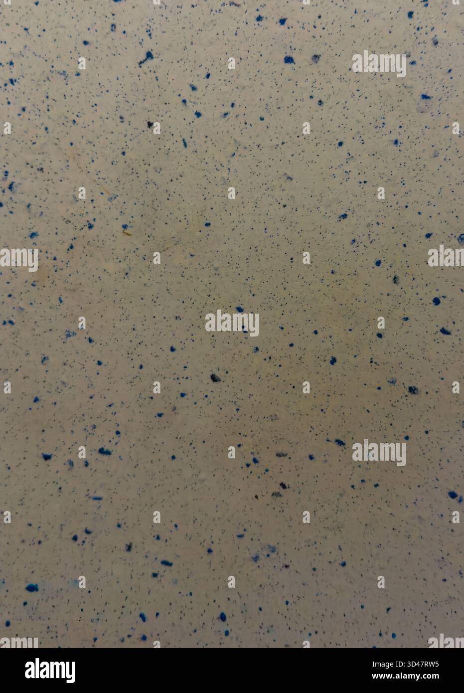 Abstract beige surface with scattered blue specks and grainy texture Stock Photo