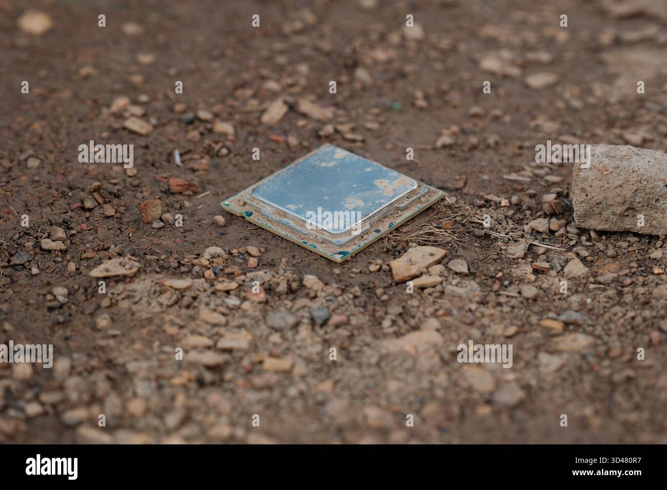 Discarded computer processor lying on soil Stock Photo