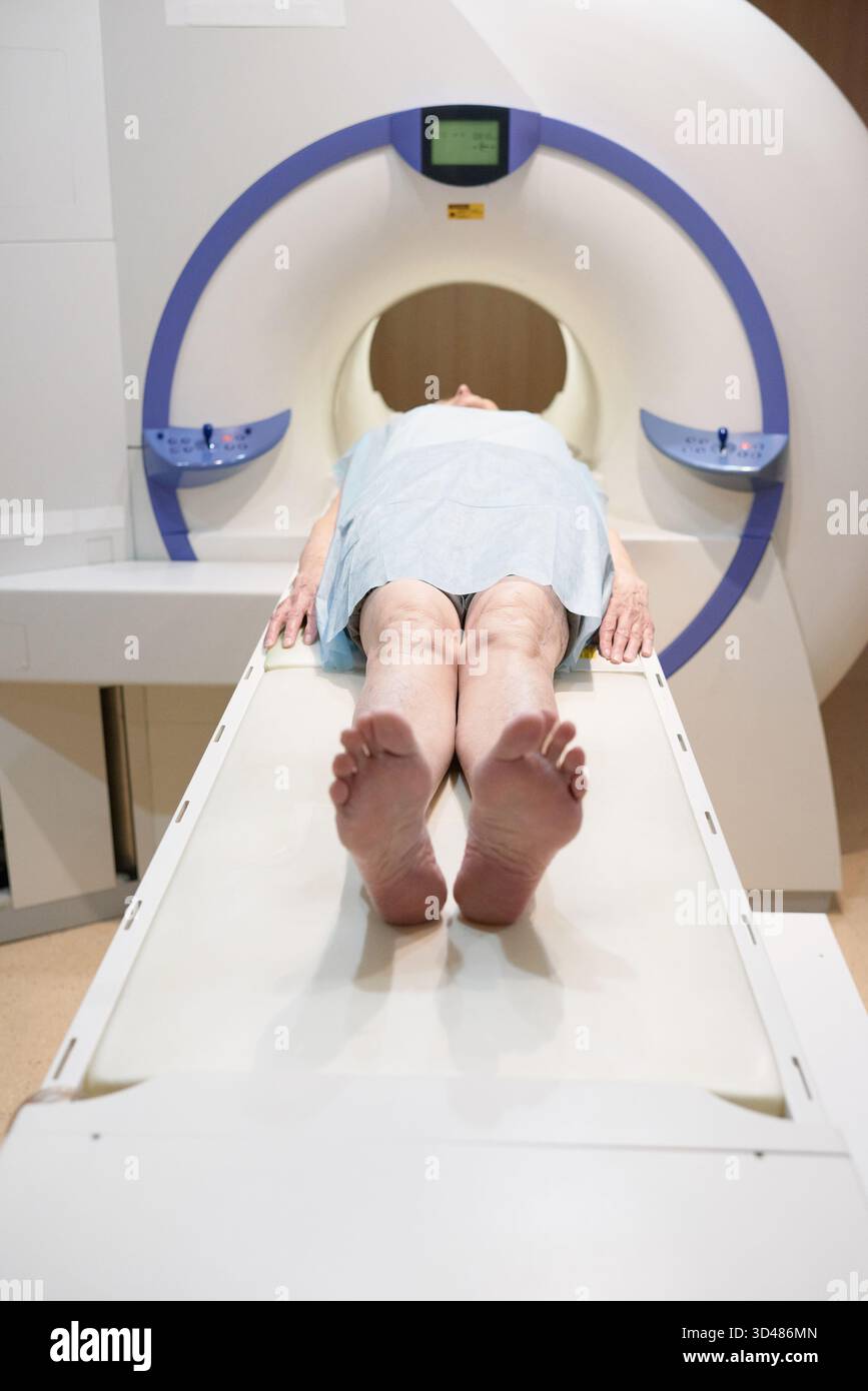 Through Scan Unrecognizable mature woman going through scan of MRI machine while ...