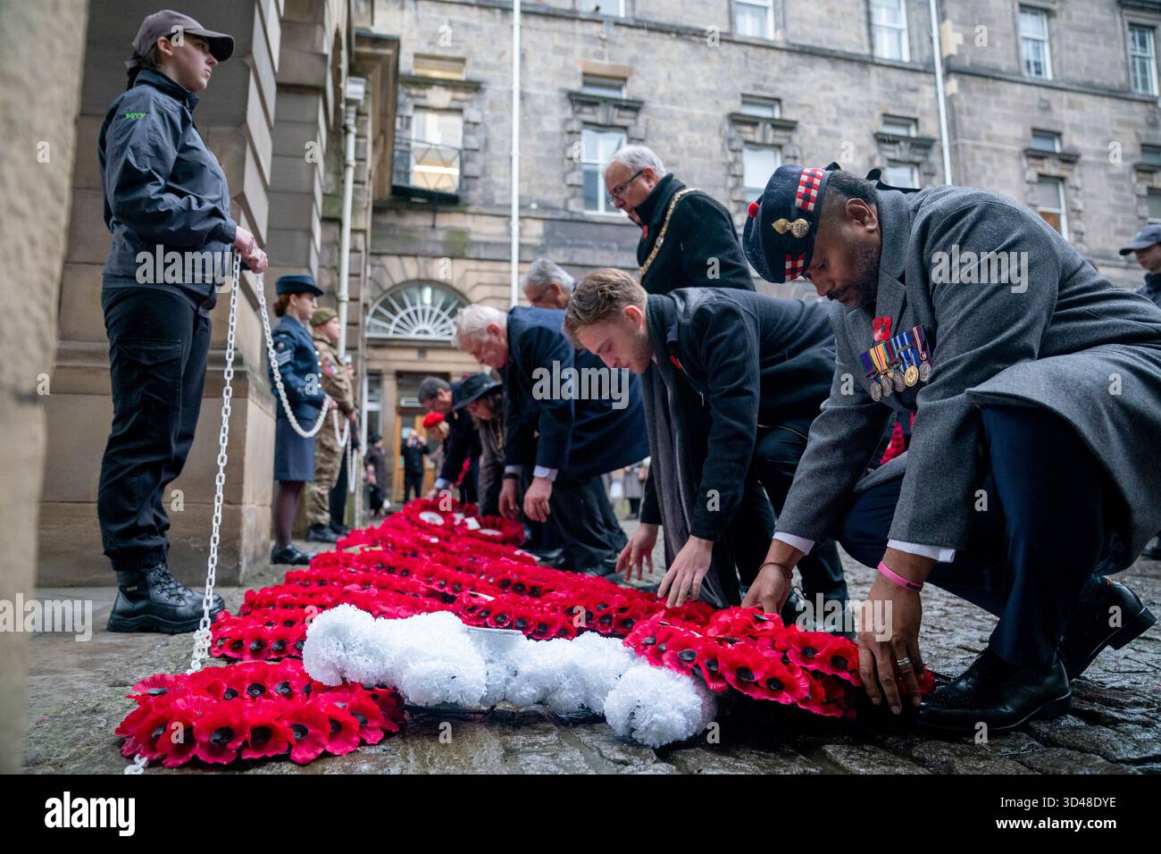 People lay wreaths during a Remembrance Sunday ceremony at the Stone of ...