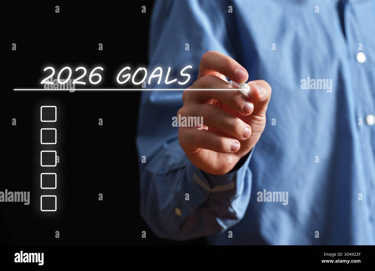 Hand of a man writing out a list of 2026 goals, concept for future planning and resolution Stock Photo