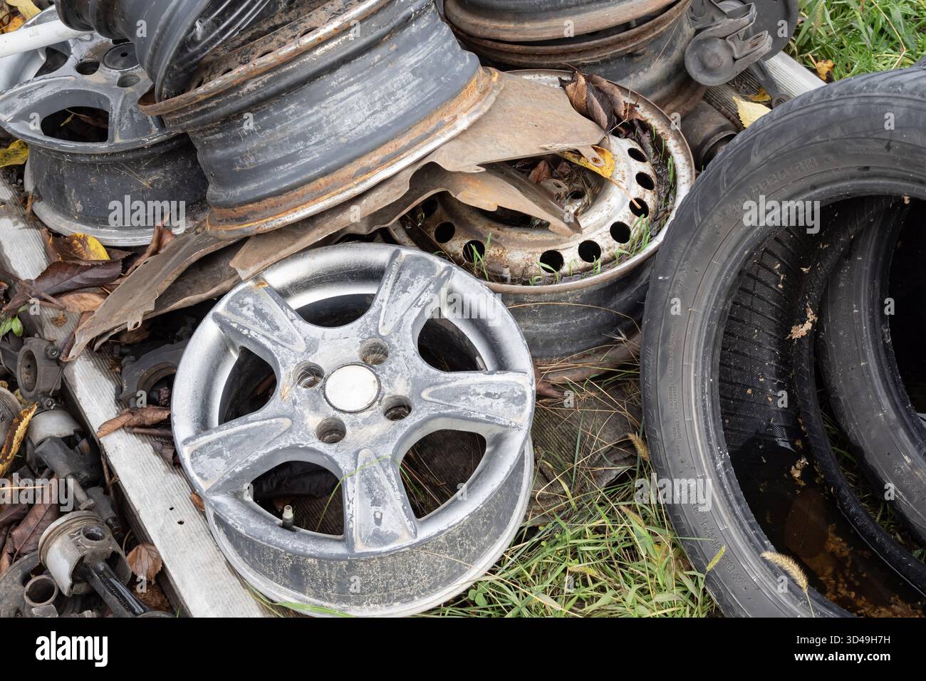 Rust Behind Rims Old car wheel rims with rust and dirt in a metal scrapyard. Industrial ...