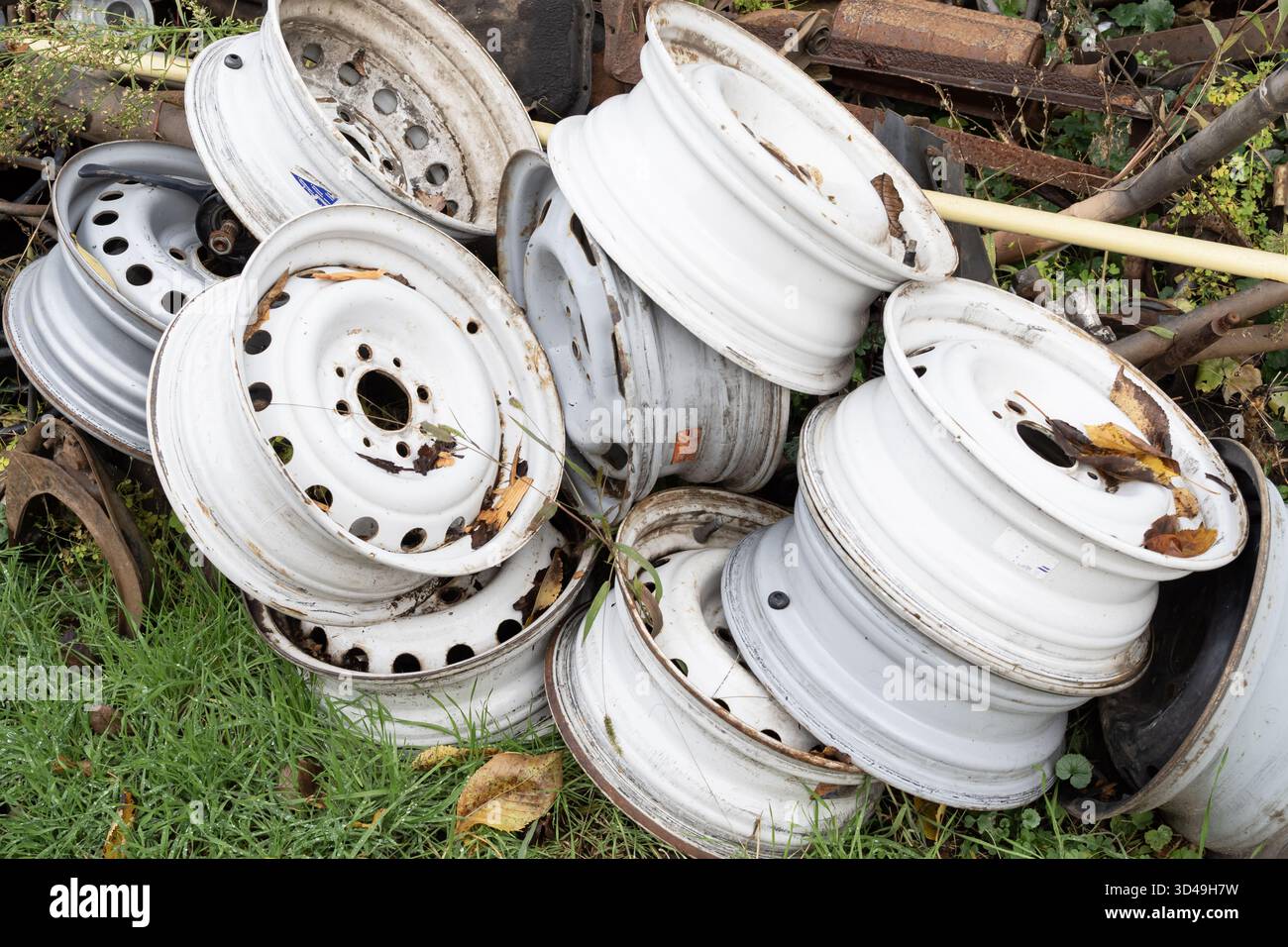Reuse Car Rims Old car wheel rims with rust and dirt in a metal scrapyard. Industrial ...