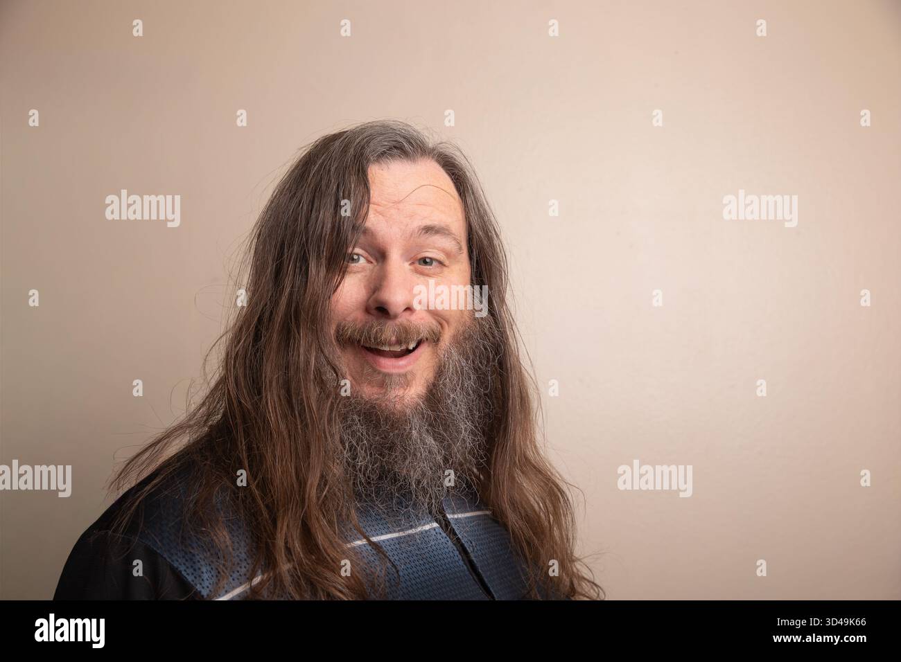 A man with a beard and long hair is smiling Stock Photo