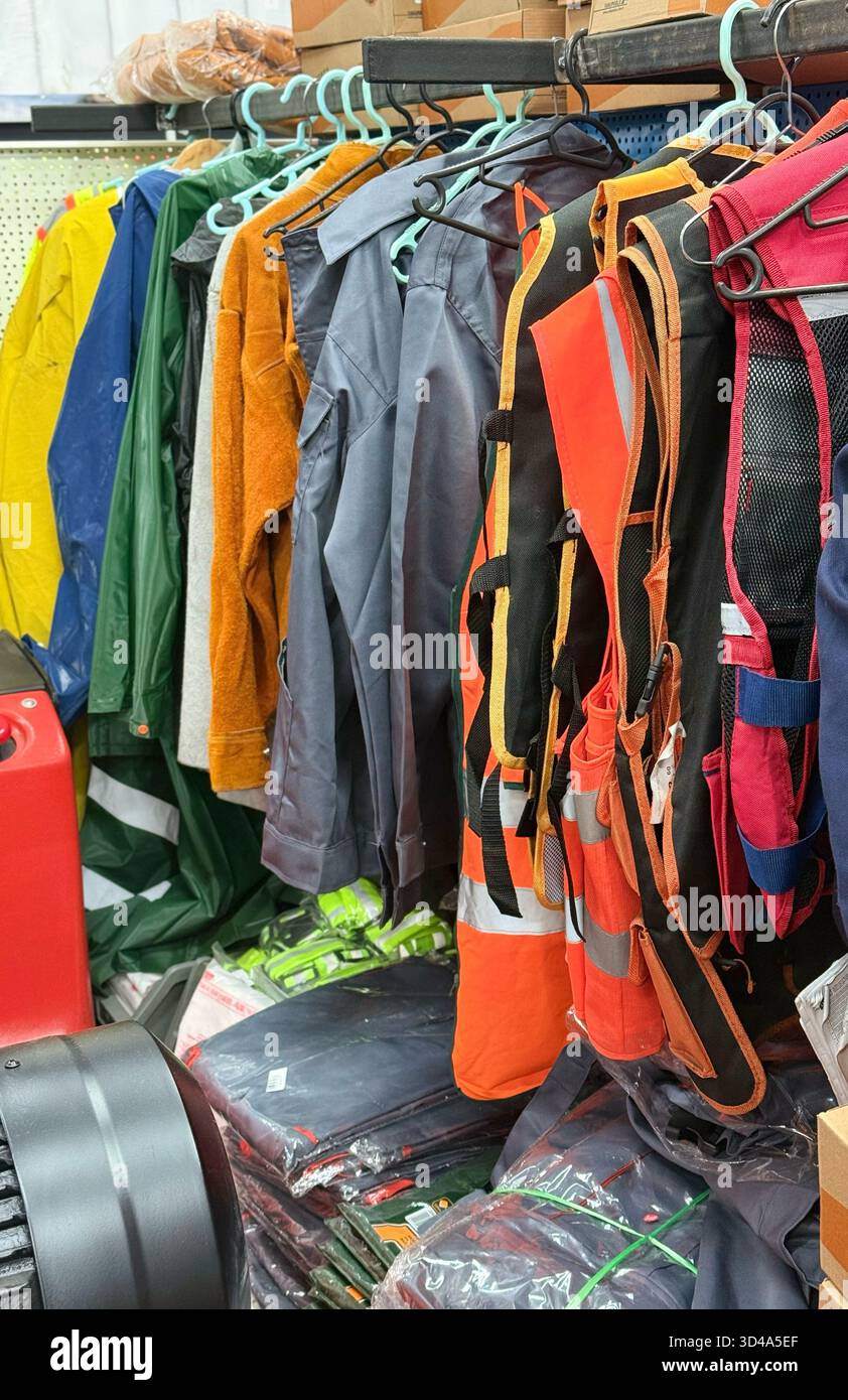 Assorted Workwear and Safety Vests Displayed on Store Rack Stock Photo
