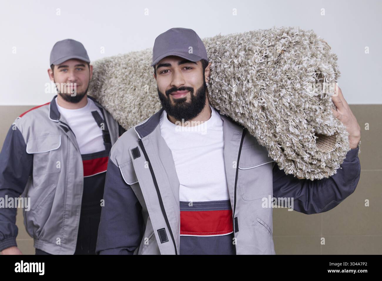 Happy male carrying a carpet in new home Stock Photo