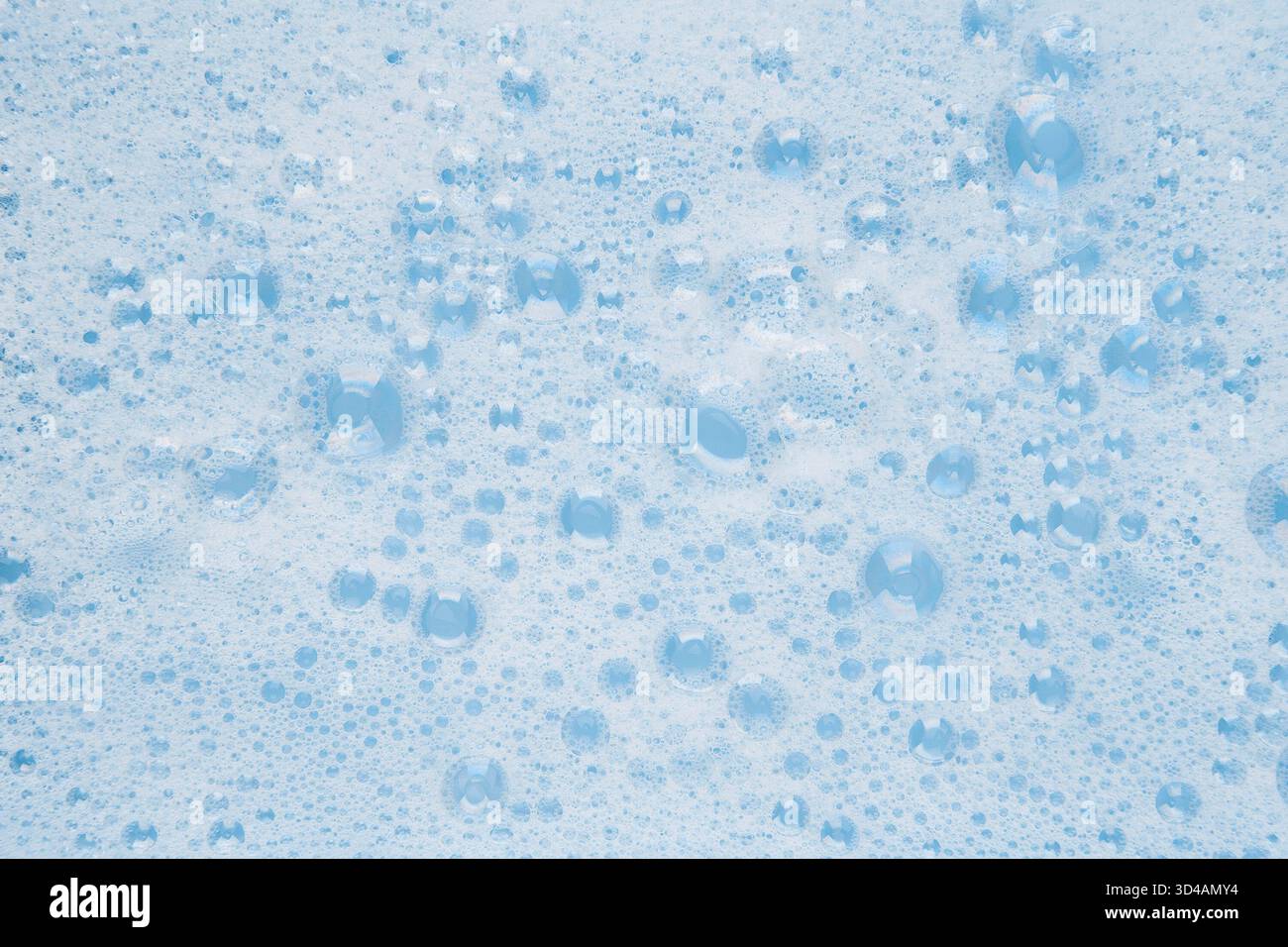 white soapy water on a blue background. Stock Photo