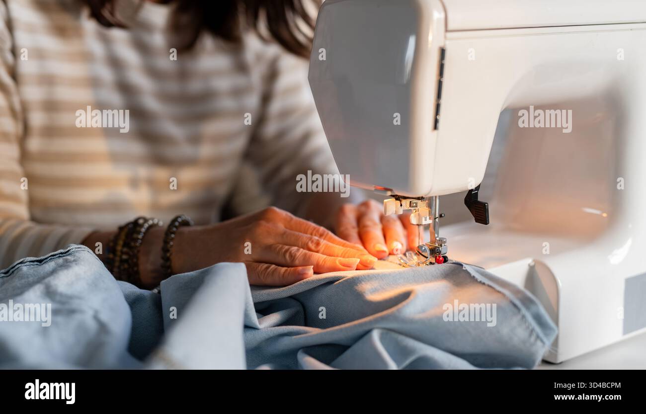 Woman's Hands Sewing On A Machine In Close-Up Stock Photo