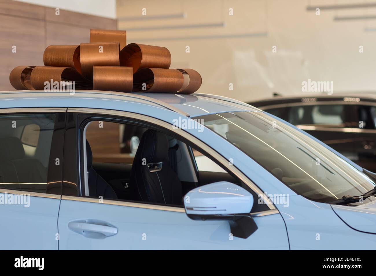 An iconic new car is being presented with a ribbon bow at the showroom ...