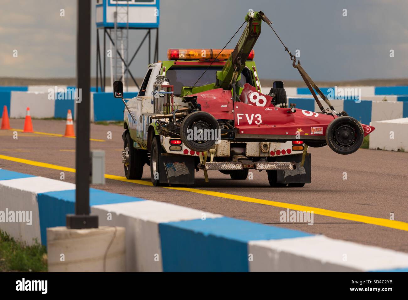 Tow Truck Lifts Red Race Car On Track During Salvage Operation At Racing Circuit Stock Photo