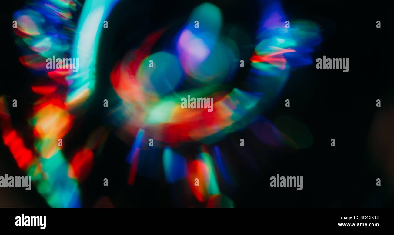 Gradient bokeh reflection. Shimmering glow. Red green circles sparks flow on black background. Colorful beam defocused abstract texture. Stock Photo