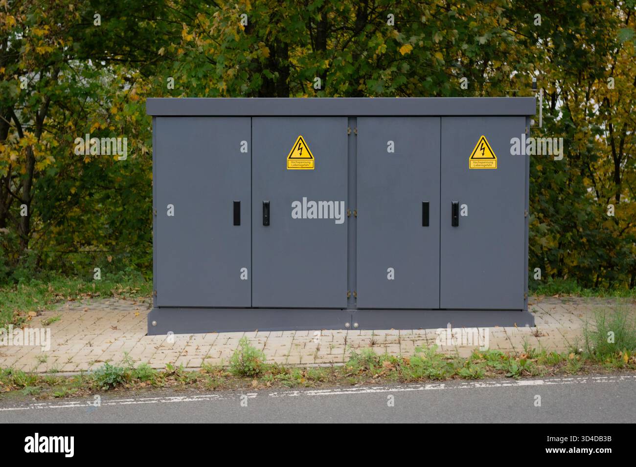 Electrical distribution cabinet with warning signs by the roadside ...
