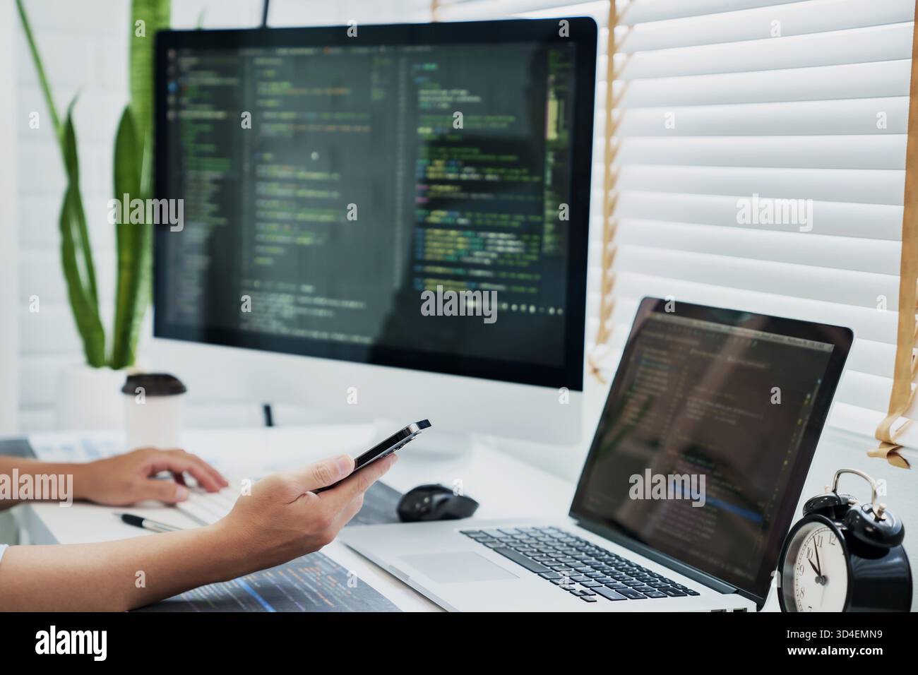 Programming developing software application. programmer writing program code with two monitors and working hacker on a new software. || Model released Stock Photo