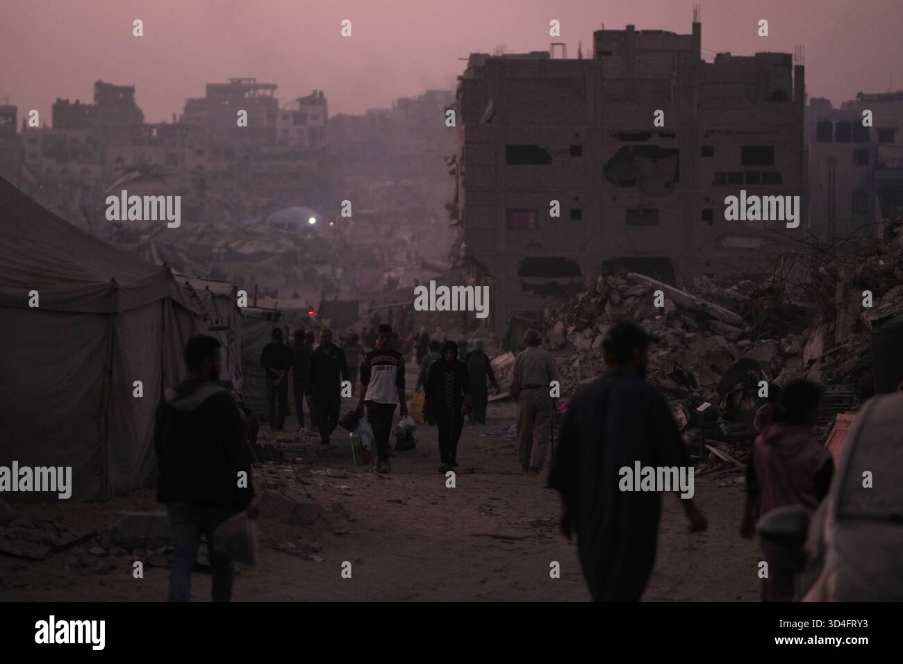 Palestinians walk through the destruction caused by the Israeli air and ...