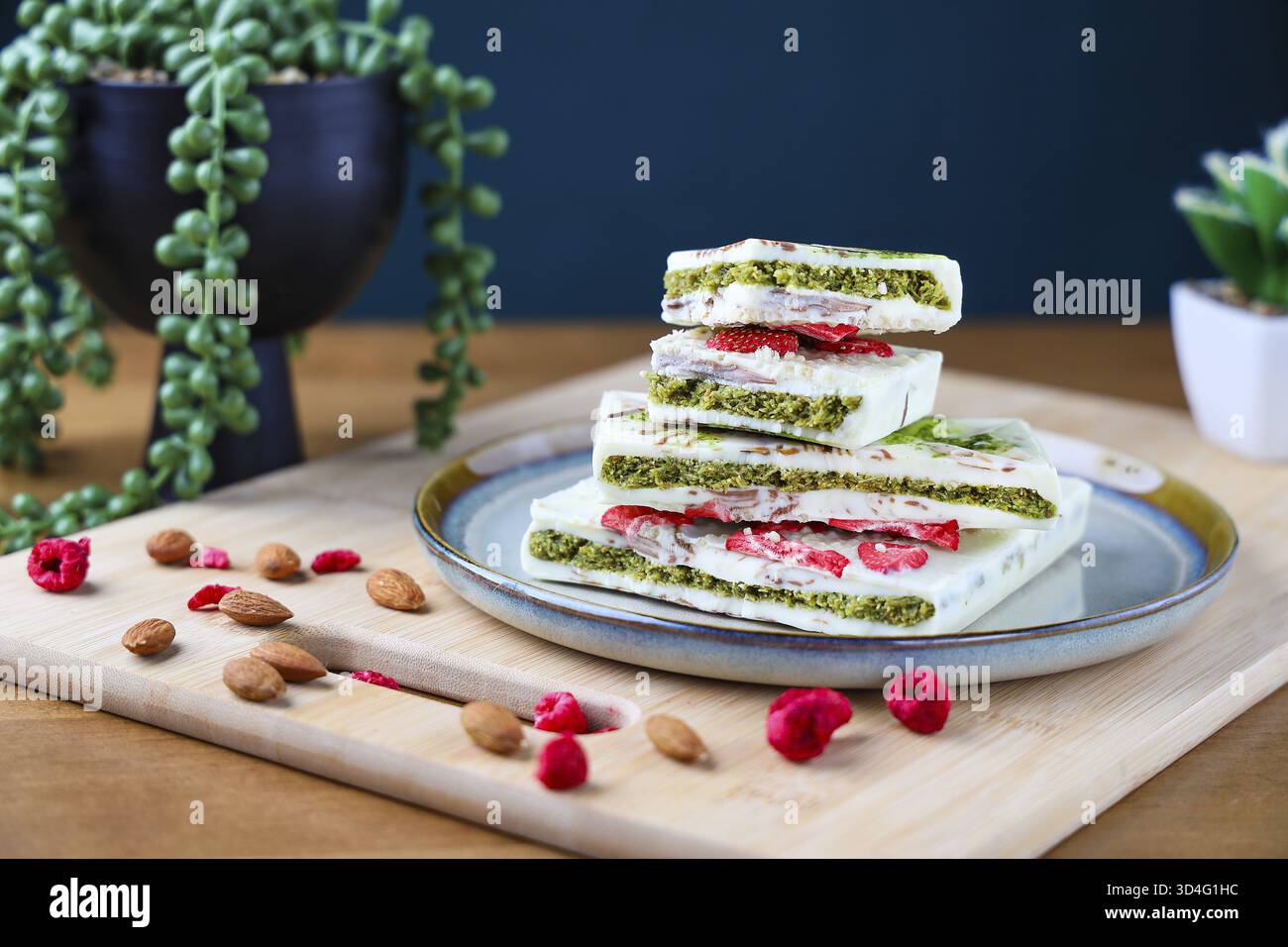 Food, Piece of trend Dubai white chocolate with pistachio paste and kataifi dough, Confectionery handmade sweets at home in the kitchen. Stock Photo