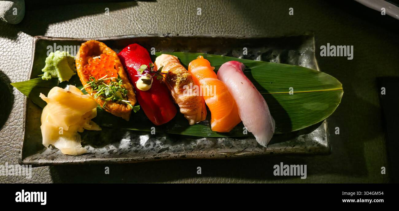 Colorful sushi platter showcases fresh ingredients arranged artistically on a dark plate, highlighting culinary craftsmanship and vibrant colors. - Smartphone Captured Stock Image