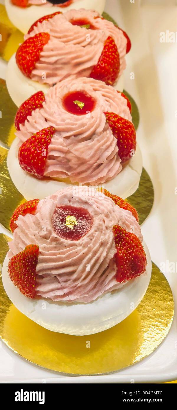 Elegant strawberry desserts are beautifully arranged on golden plates, showcasing intricate designs and vibrant colors, perfect for celebrations and e - Smartphone Captured Stock Image