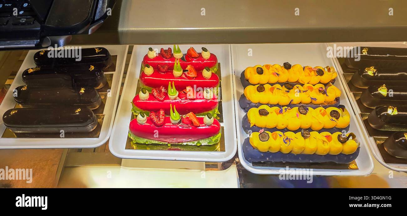 Colorful pastries are beautifully arranged in a bakery display, showcasing vibrant textures and enticing designs, perfect for dessert lovers. - Smartphone Captured Stock Image