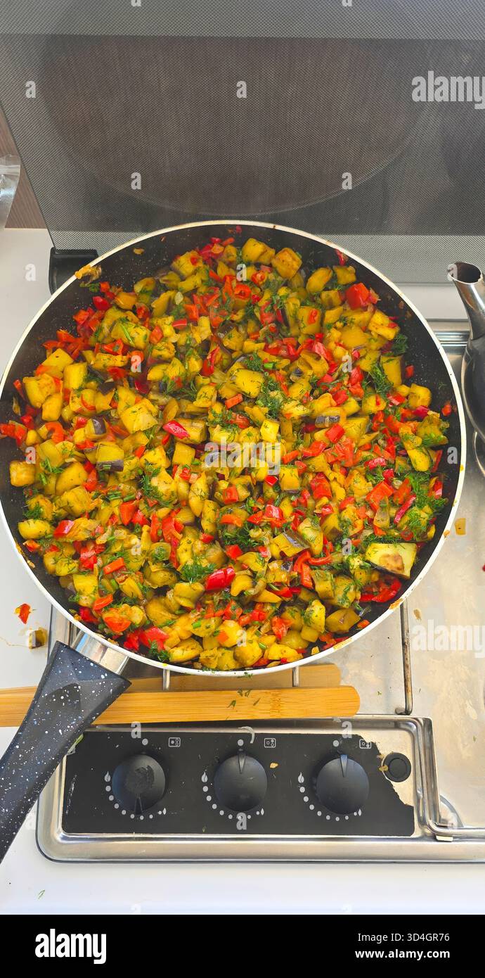 . Colorful stir-fried vegetables in a frying pan on a modern kitchen stove, showcasing vibrant ingredients and healthy cooking techniques - Smartphone Captured Stock Image