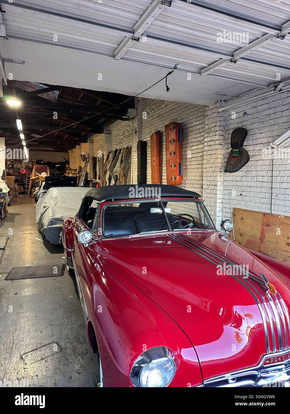 Red 1950s Pontiac convertible in auto upholstery workshop, California - Smartphone Captured Stock Image