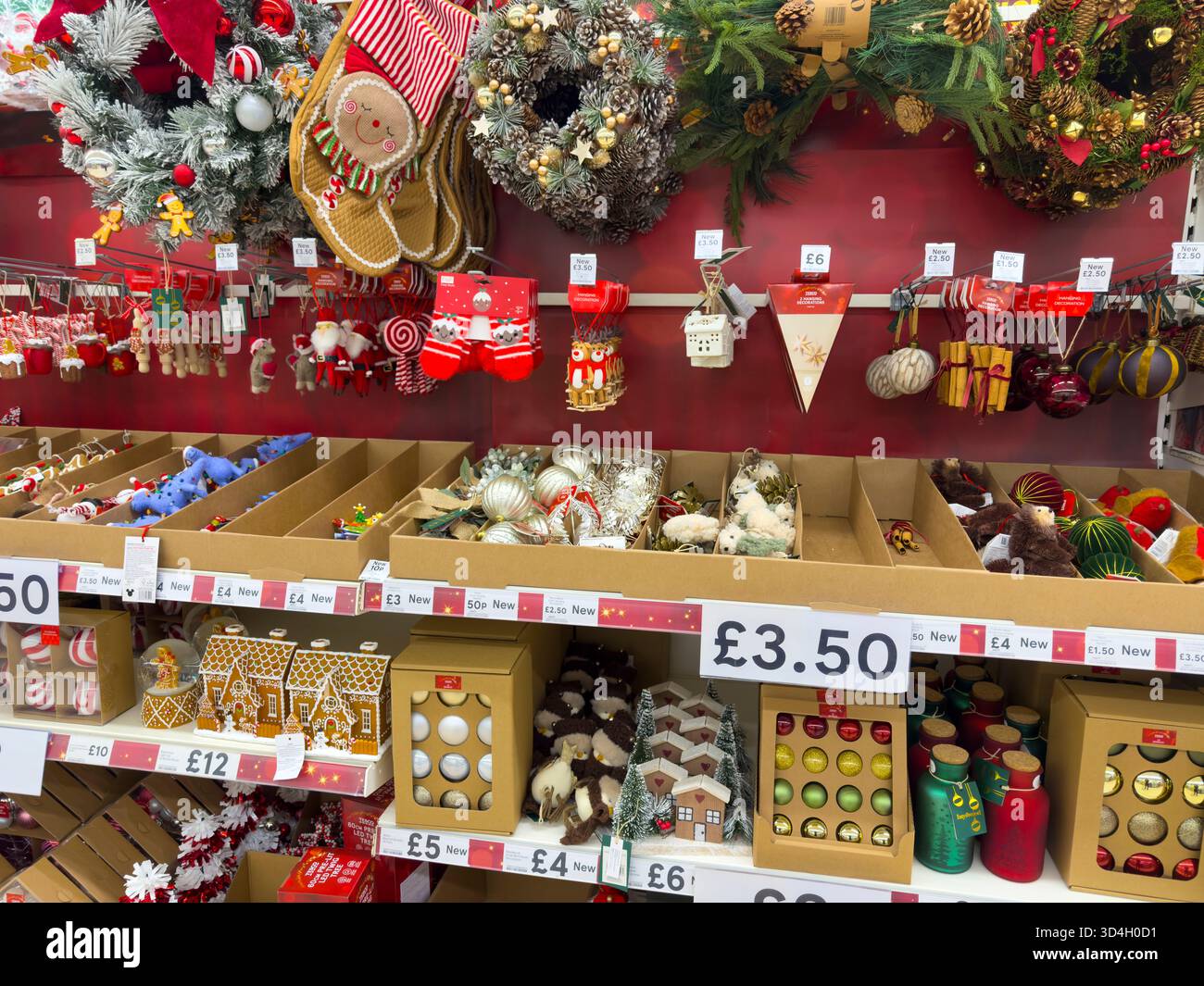 Tesco supermarket Christmas merchandising aisle with festive decorations, baubles, and holiday signage – UK retail display: Phillip Roberts - Smartphone Captured Stock Image