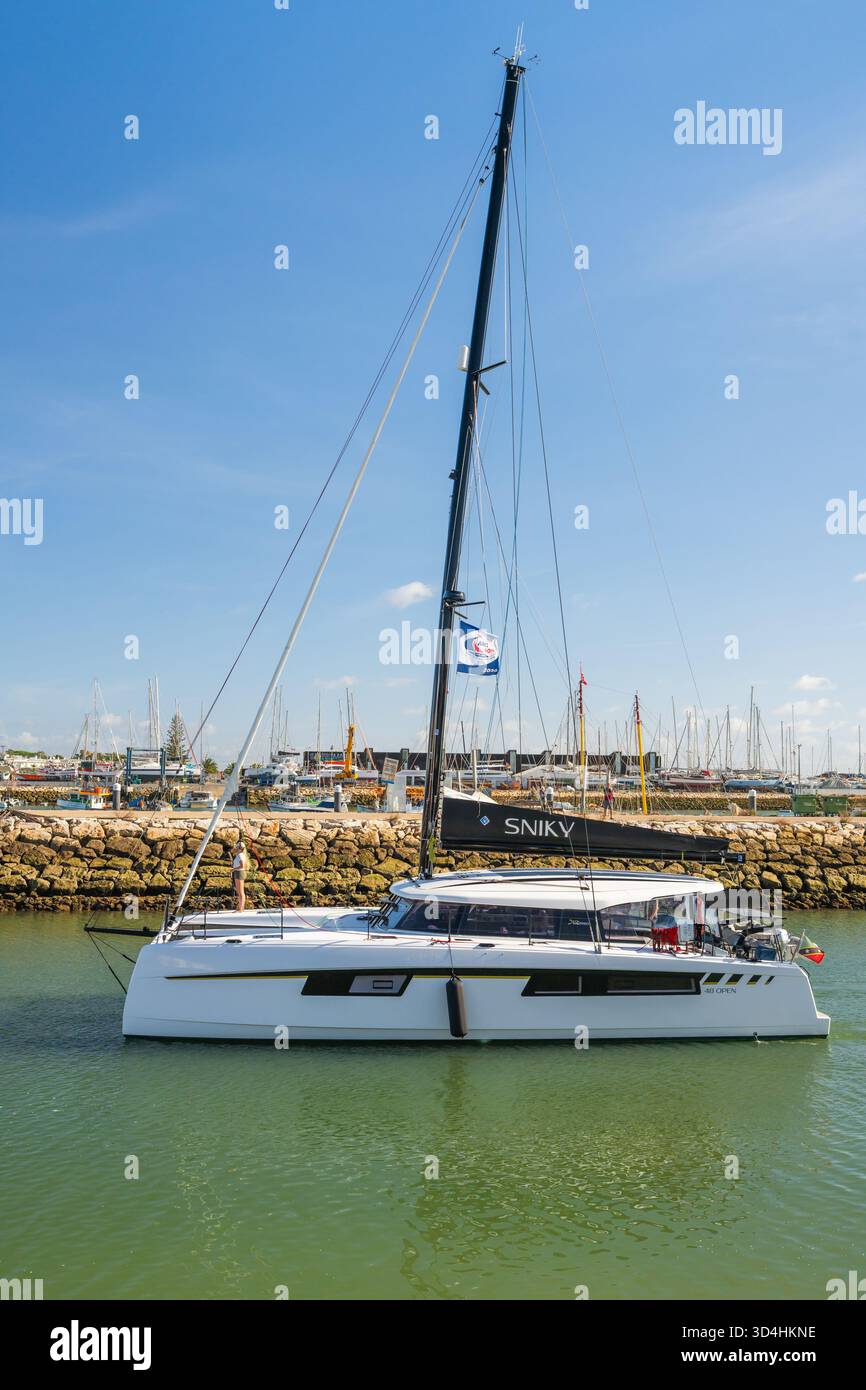 Lagos, Portugal, November 8, 2025, the catamaran Sniky approaches the marina edge with a clear view of nearby docked vessels. Stock Photo
