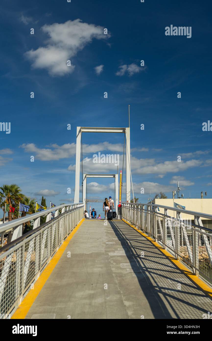 Lagos, Portugal, November 8, 2025. Visitors make their way across the modern pedestrian drawbridge that links the town center with the marina area. Stock Photo