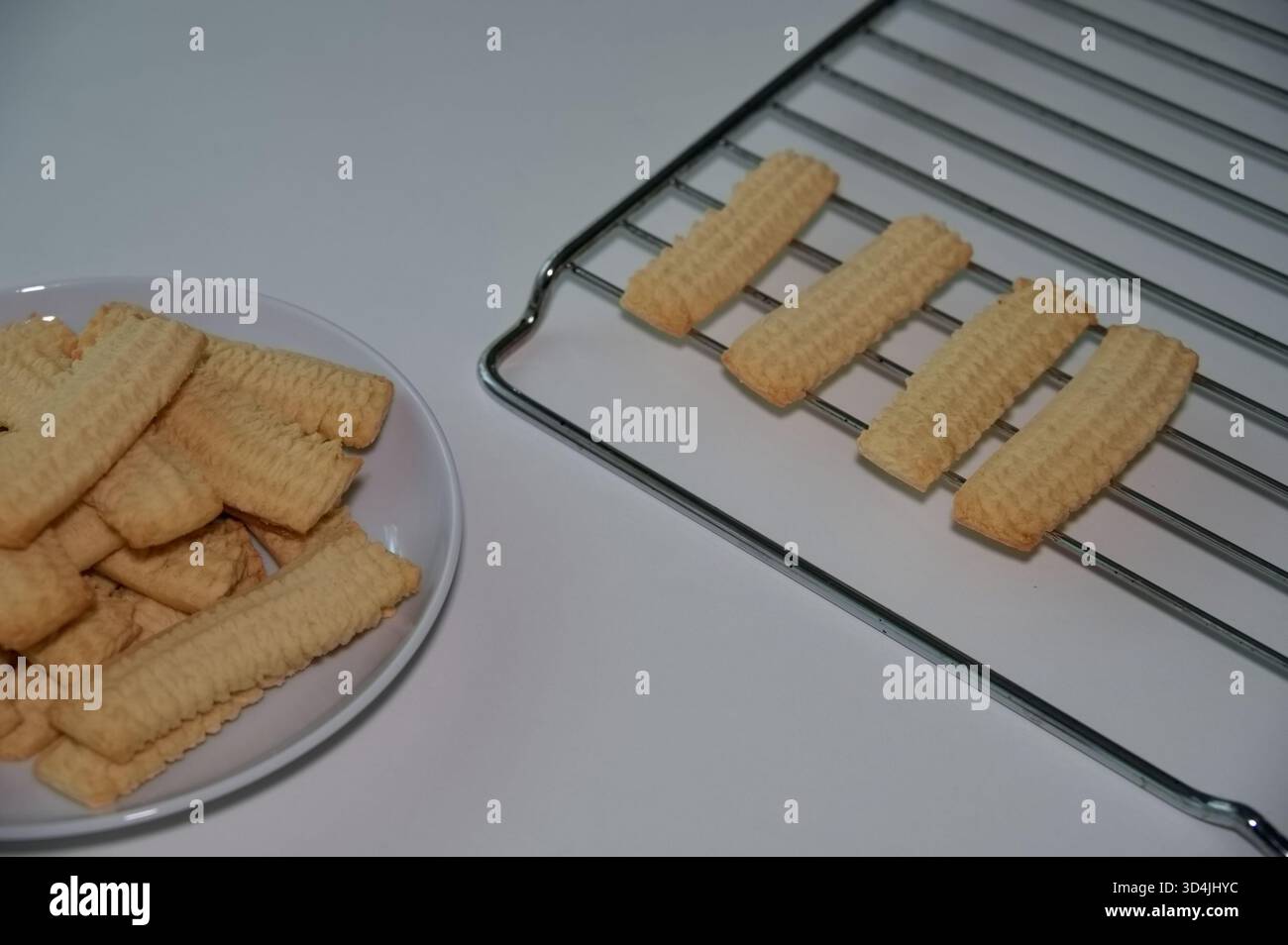 Biscuits on the plate and baking rack against white background Stock Photo