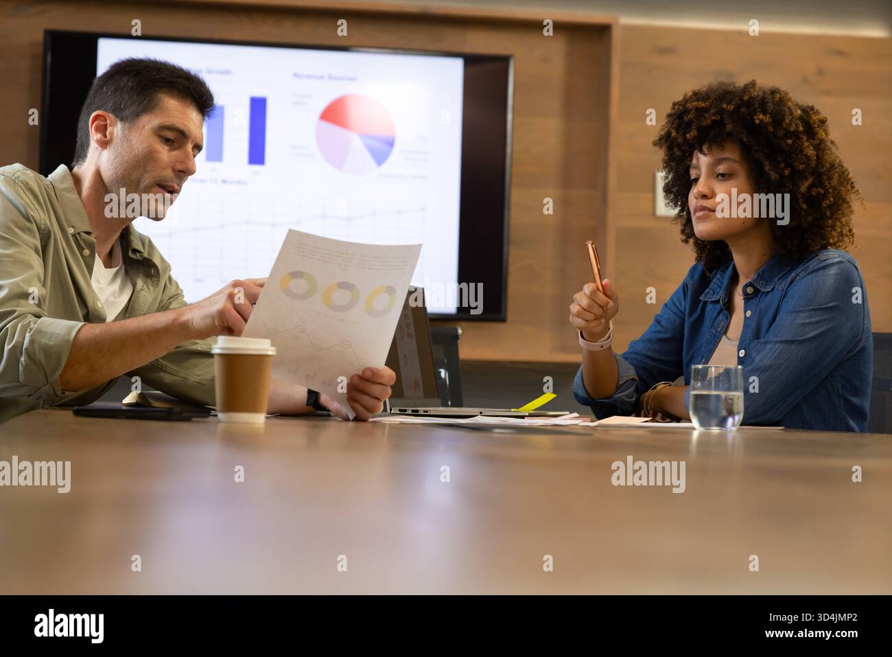 Reviewing Diverse coworkers analyzing printed report at office ...
