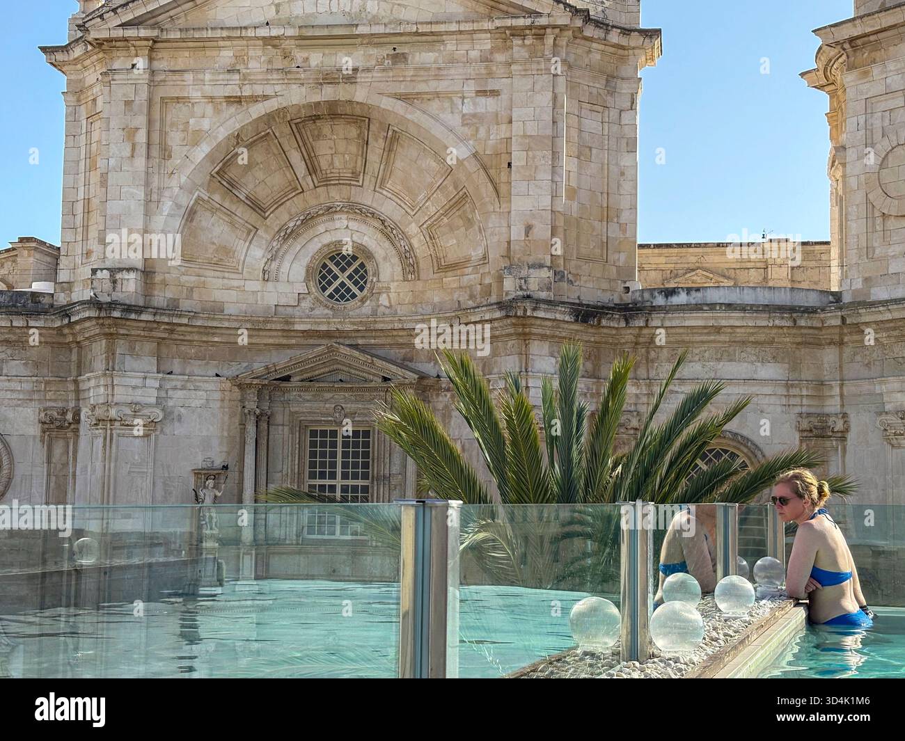 Cadiz Cathedral, young couple in the rooftop swimming pool of Hotel Olom in Cadiz city centre, Andalusia,Spain,Europe - Smartphone Captured Stock Image