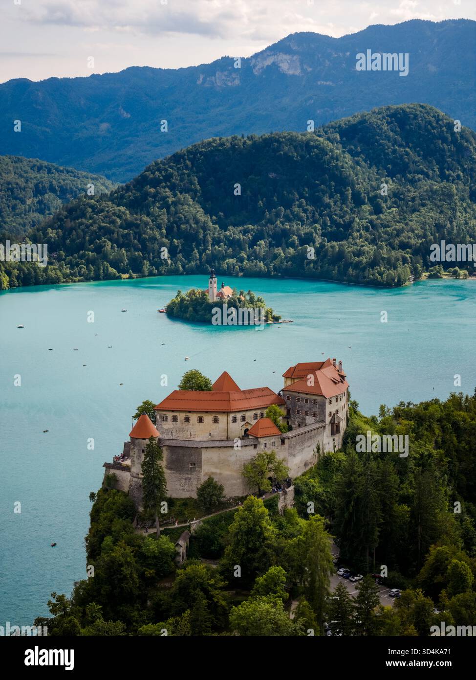Aerial view of the Bled Castle standing majestically atop a cliff ...