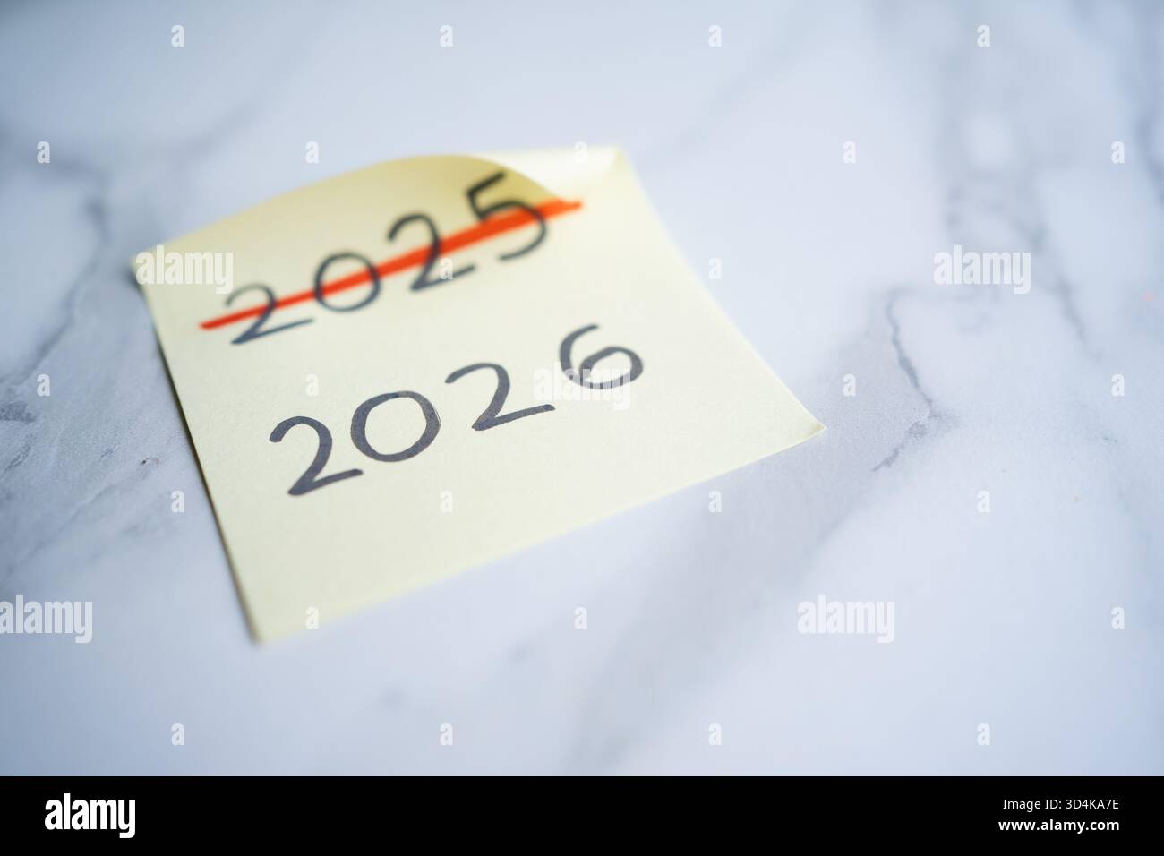 Sticky note showing 2025 crossed out and updated to 2026 for new year ...