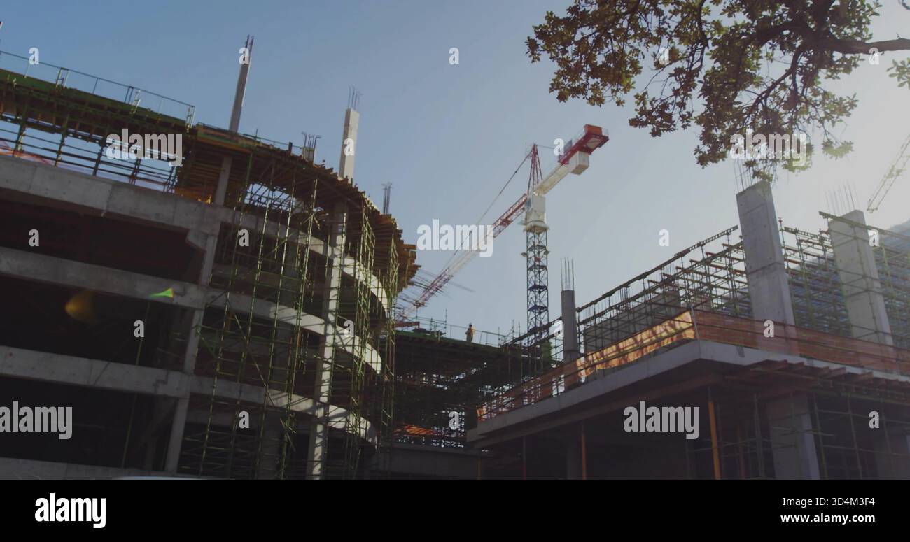 Crew building curved concrete structure on left at urban site, in ...