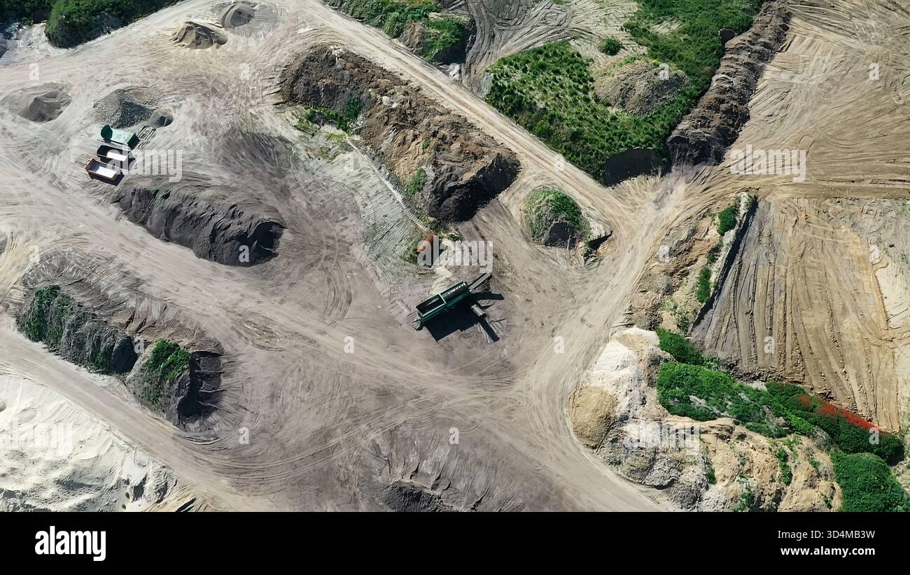 Aerial view discovering a construction site or quarry with various soil types and machinery, illustrating earth material handling Stock Photo