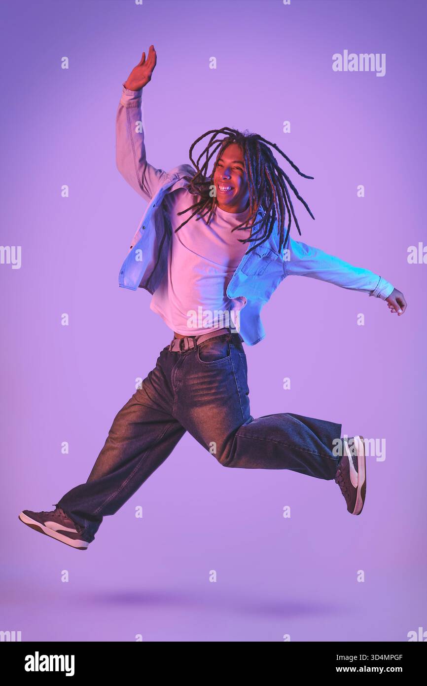 Young man with dreadlocks jumping with joy Stock Photo