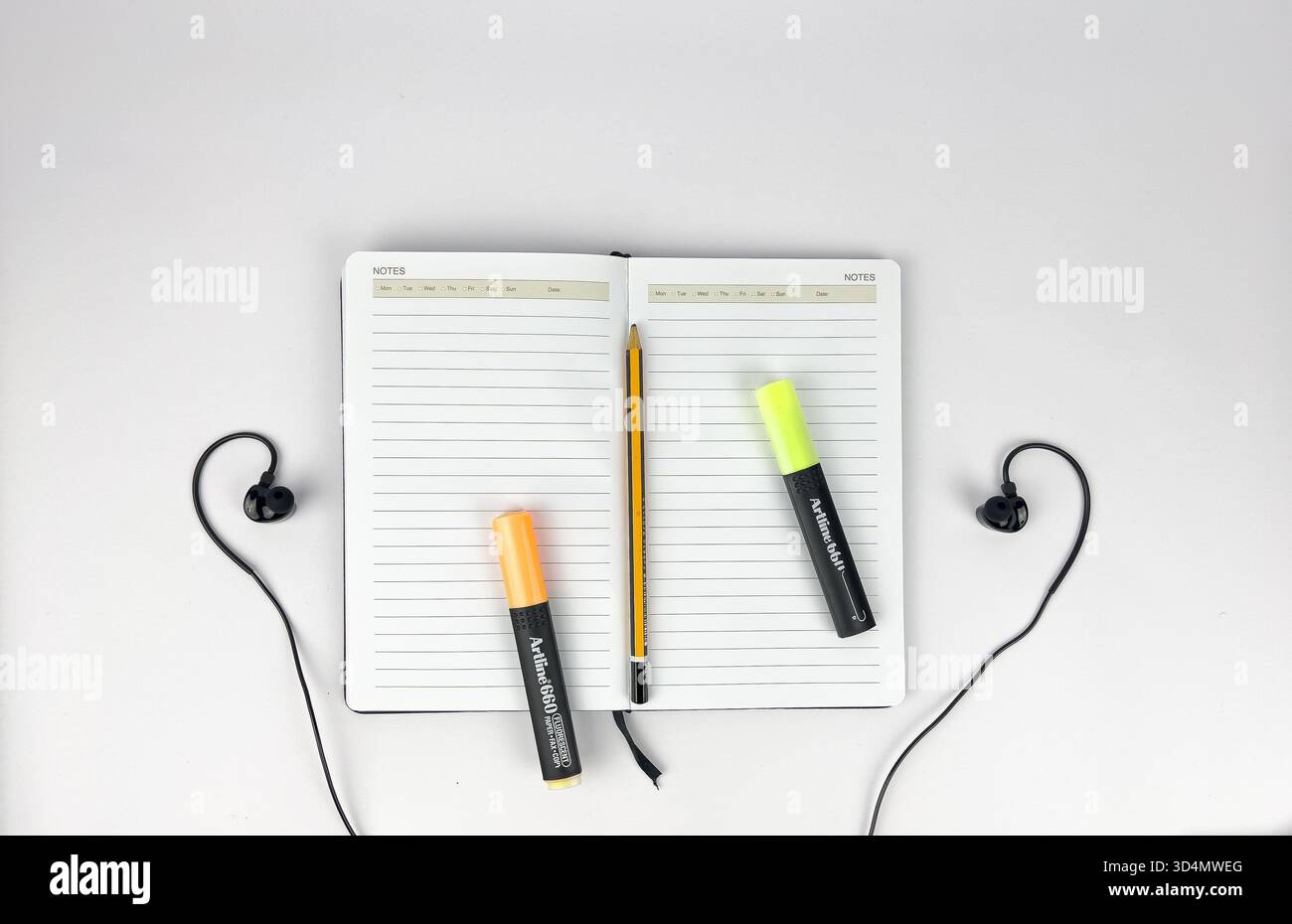 This is a flat lay or top-down view of a clean, minimalist workspace setup. The main subjects are lined notebook or journal and a modern devices Stock Photo