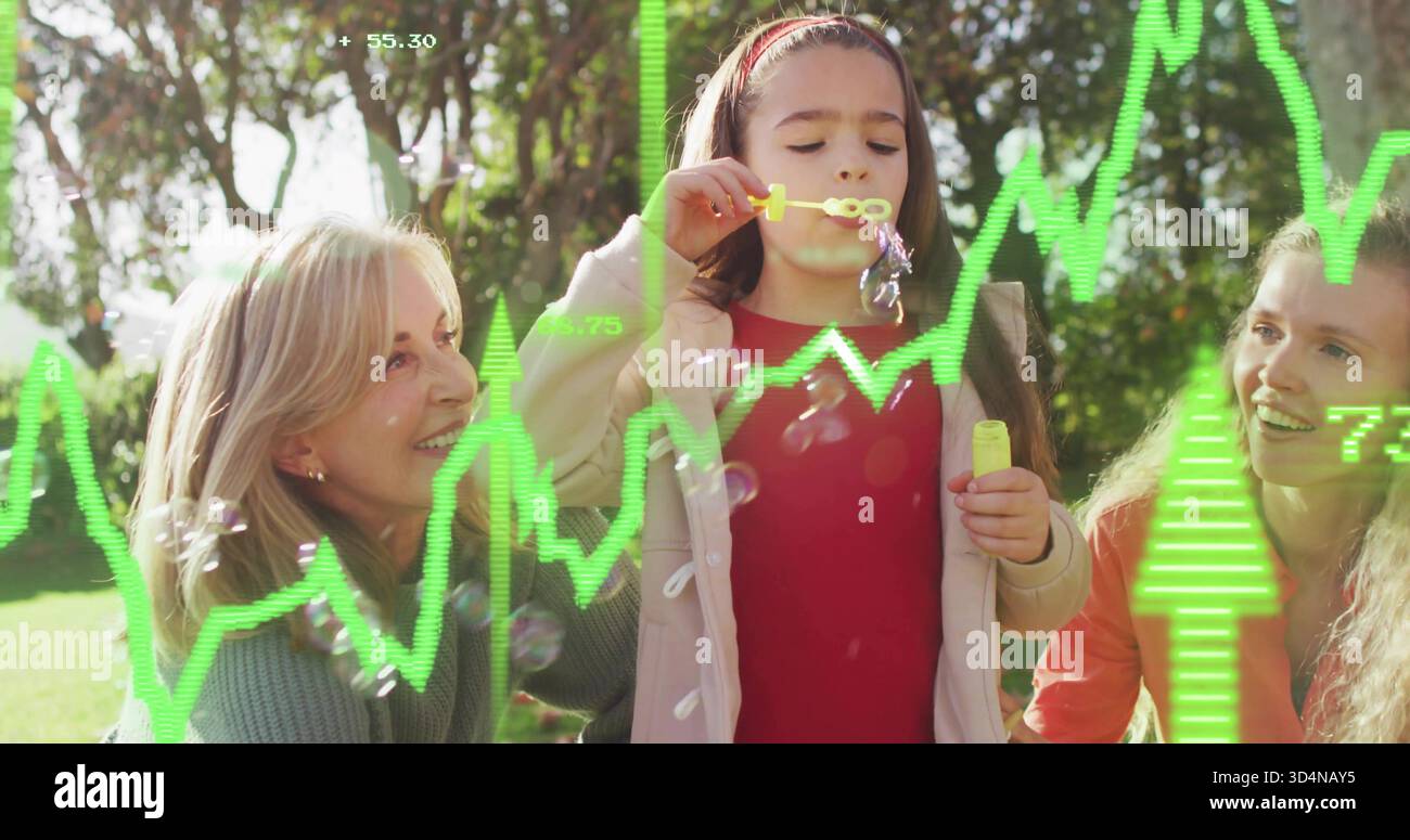 Blowing child in red top making soap bubbles in sunlit park with yellow wand, green overlays Stock Photo