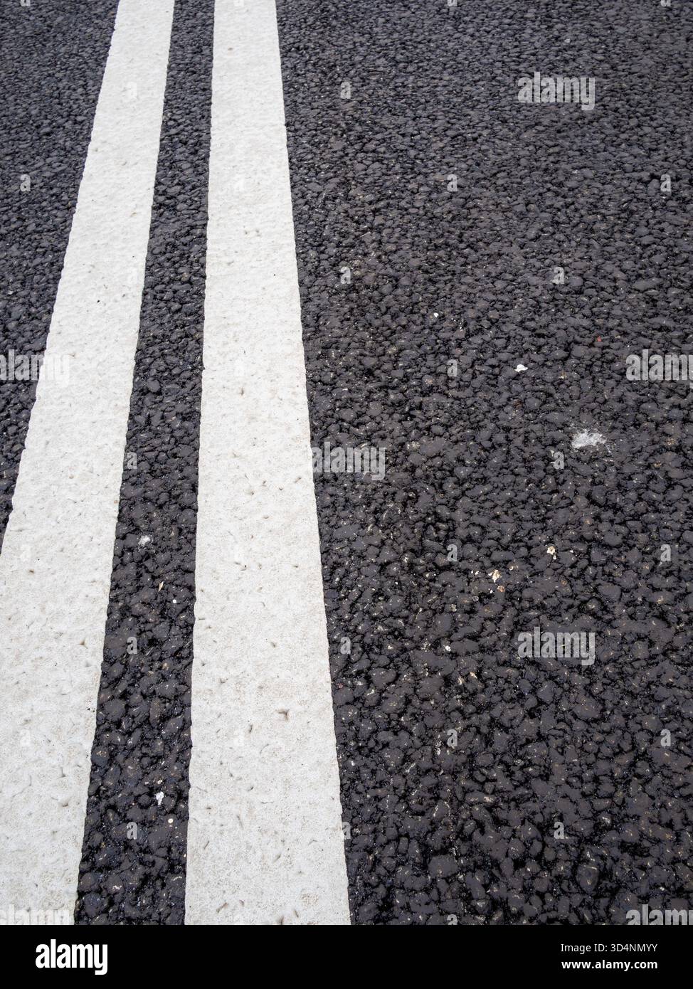 freshly white painted double solid lines on new asphalt road Stock Photo