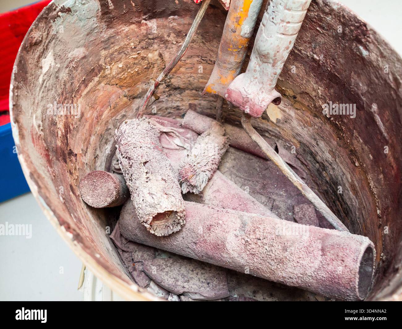 several dried used paint rollers in plastic bucket closeup Stock Photo